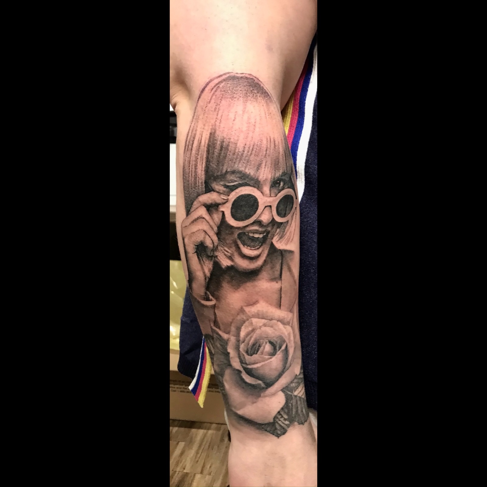 Winking girl with sunglasses and rose tattoo